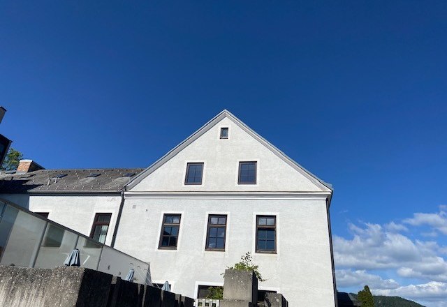 Seminarzentrum Raach, © Wiener Alpen Weißes Gebäude mit Giebeldach vor blauem Himmel.