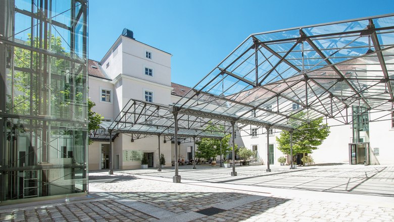Innenhof des Hotels Altes Kloster mit Glasdach und modernem Design.
