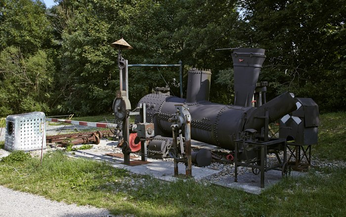 Ausstellung von alten Zahnradbahnteilen im Freien.