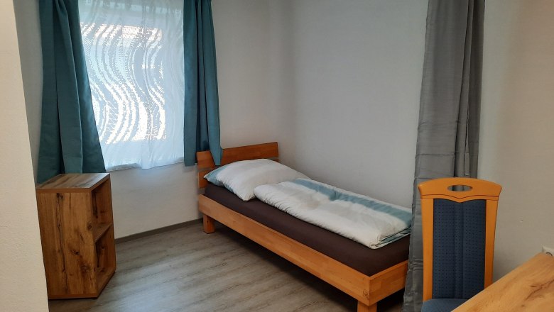 Einzelschlafzimmer mit Bett und Fenster