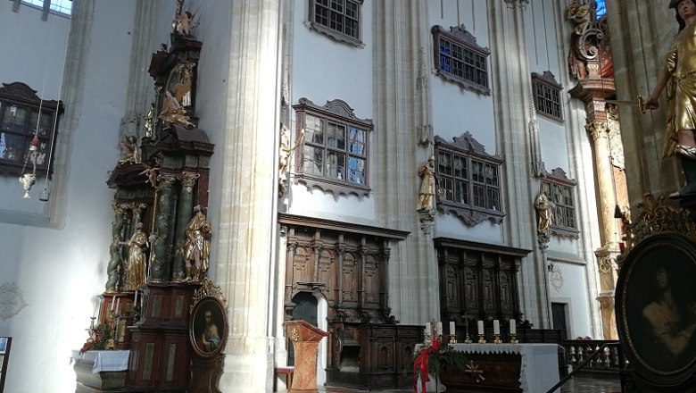 Innenansicht der Piaristenkirche mit Altar, Kanzel und Statuen.