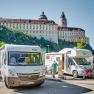 Wohnmobilstellplatz mit Wohnmobilen vor dem Stift Melk in Österreich.