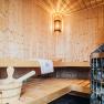Innenansicht einer Holzsauna mit Saunaofen und Holzeimer.