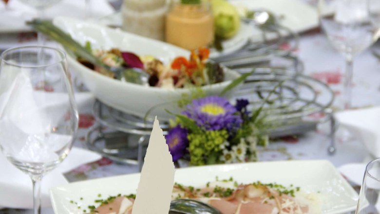 Ein gedeckter Tisch mit verschiedenen Speisen und Blumenarrangements.