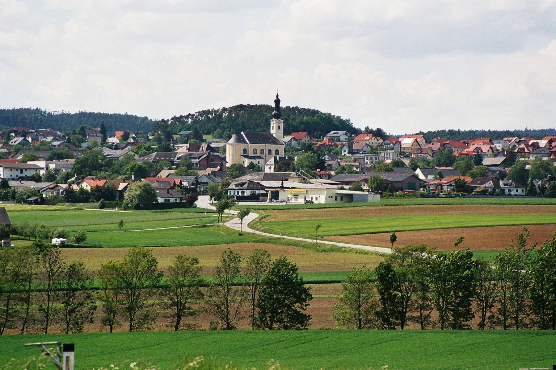 Panorama der Marktgemeinde Karlstetten mit Kirche und umliegenden Feldern.