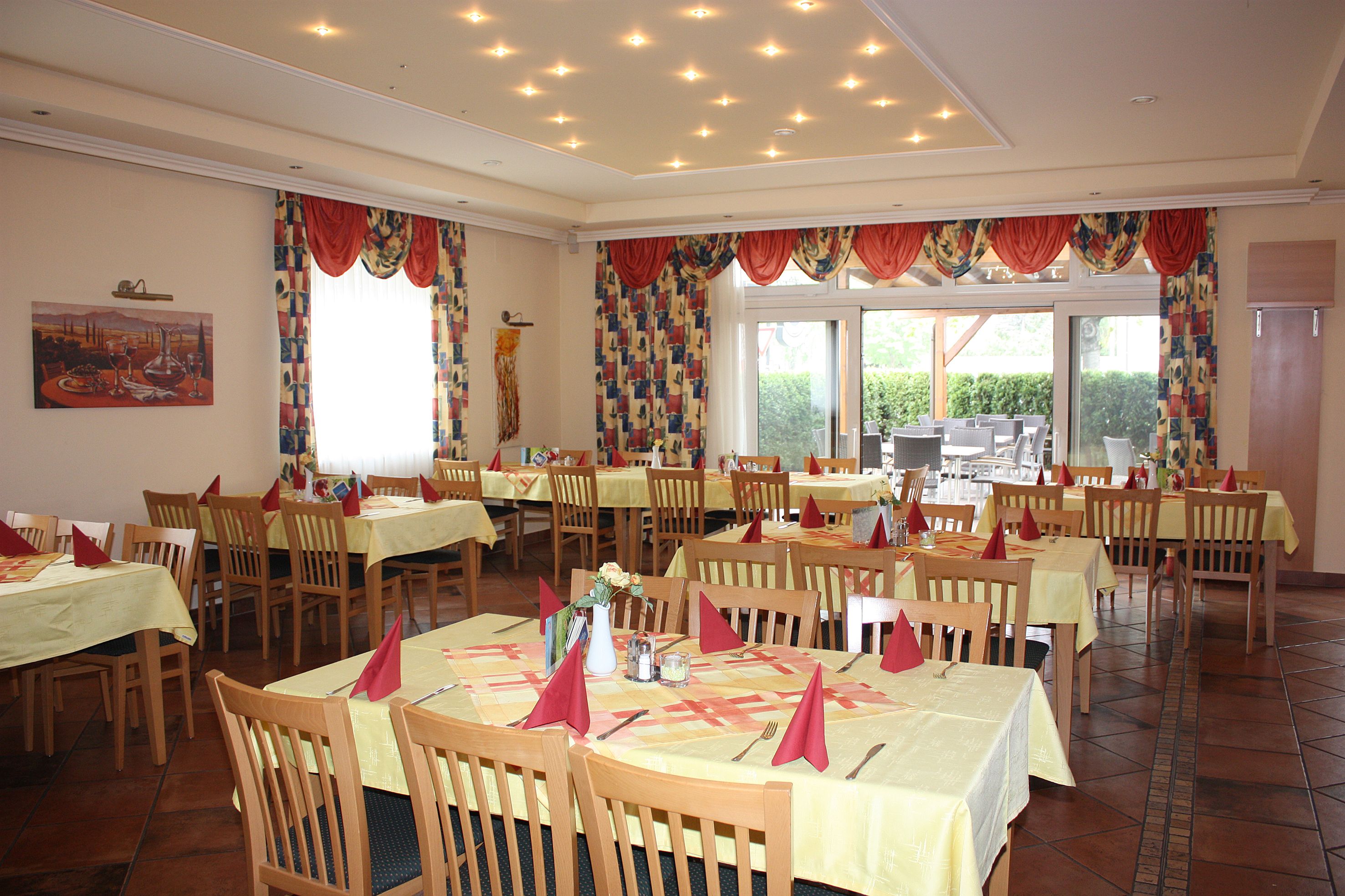 Ein elegantes Restaurant mit gedeckten Tischen und roten Servietten.