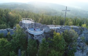 Der Aussichtspunkt auf dem Nebelstein bietet einen atemberaubenden Blick &uuml;ber die umliegenden W&auml;lder und Berge. Die frische, klare Luft und das sanfte Licht der Abendd&auml;mmerung schaffen eine magische Atmosph&auml;re, die zum Verweilen einl&auml;dt. Hier k&ouml;nnen Besucher die Sch&ouml;nheit der Natur in vollen Z&uuml;gen genie&szlig;en.