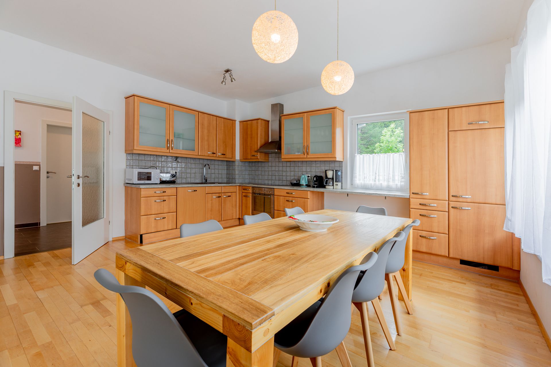 Moderne Küche mit Holzmöbeln und großem Esstisch.