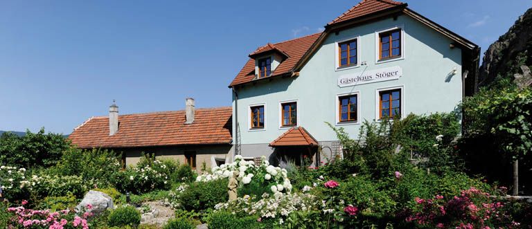Ein traditionelles Haus mit Garten, beschriftet als 'Gasthaus Stöger'.
