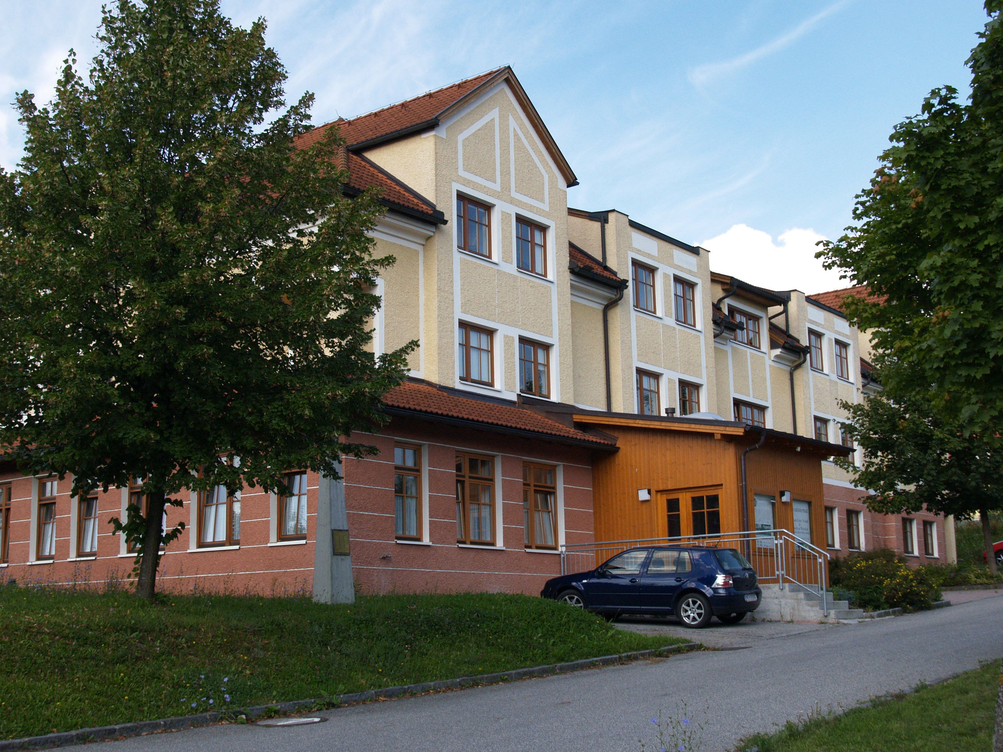 Gästehaus der HLUW-Yspertal mit geparktem Auto und Bäumen.