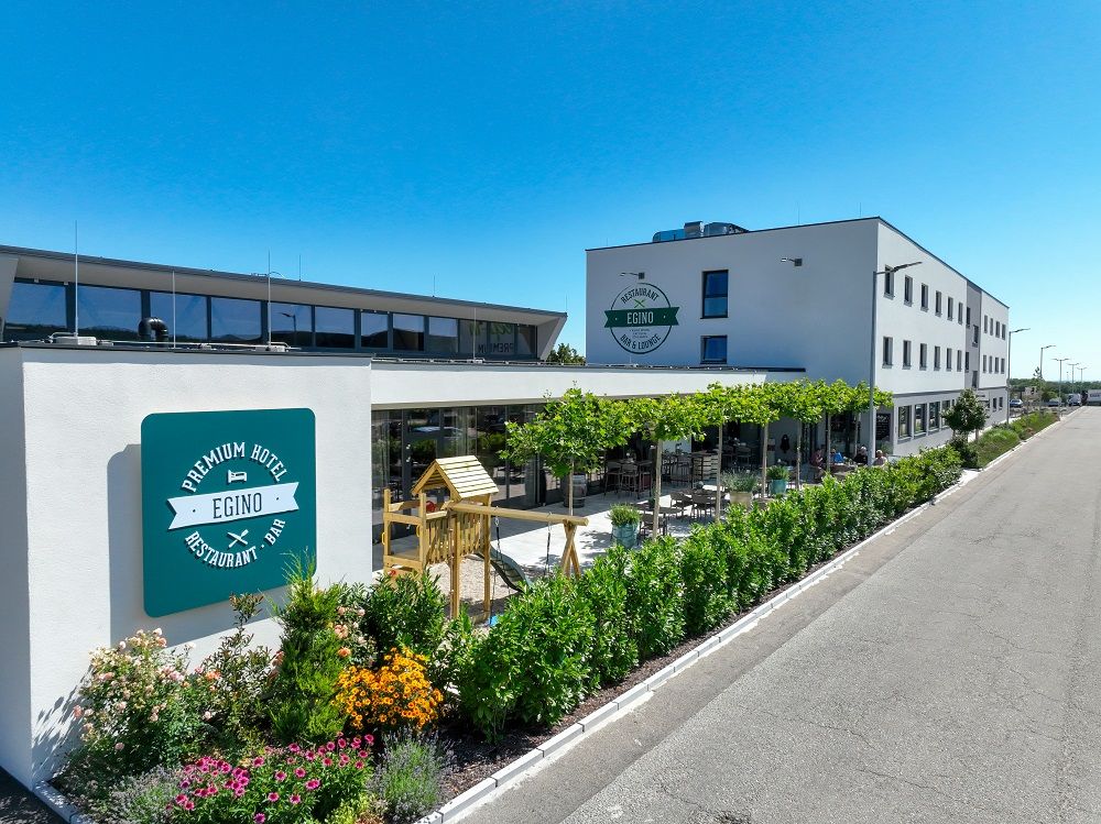 Außenansicht des Premium Hotels Egino mit Terrasse und Garten.