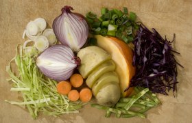 Verschiedene Gem&uuml;sesorten auf einem Holzbrett arrangiert.