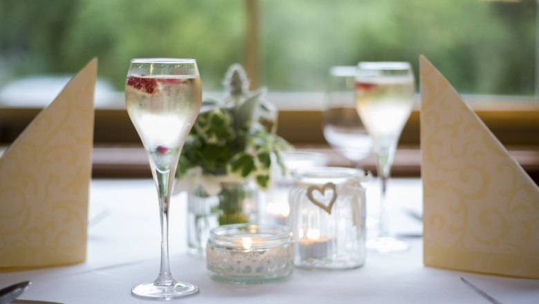 Elegante Tischdekoration mit Sektgläsern, Kerzen und Servietten.