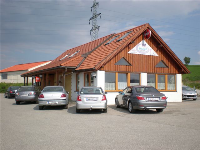 Ein Restaurant mit Holzfassade und mehreren geparkten Autos davor.