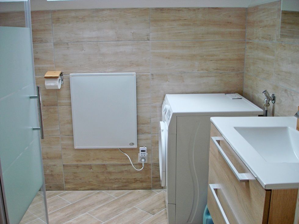 Modernes Badezimmer mit Waschmaschine und Waschbecken.