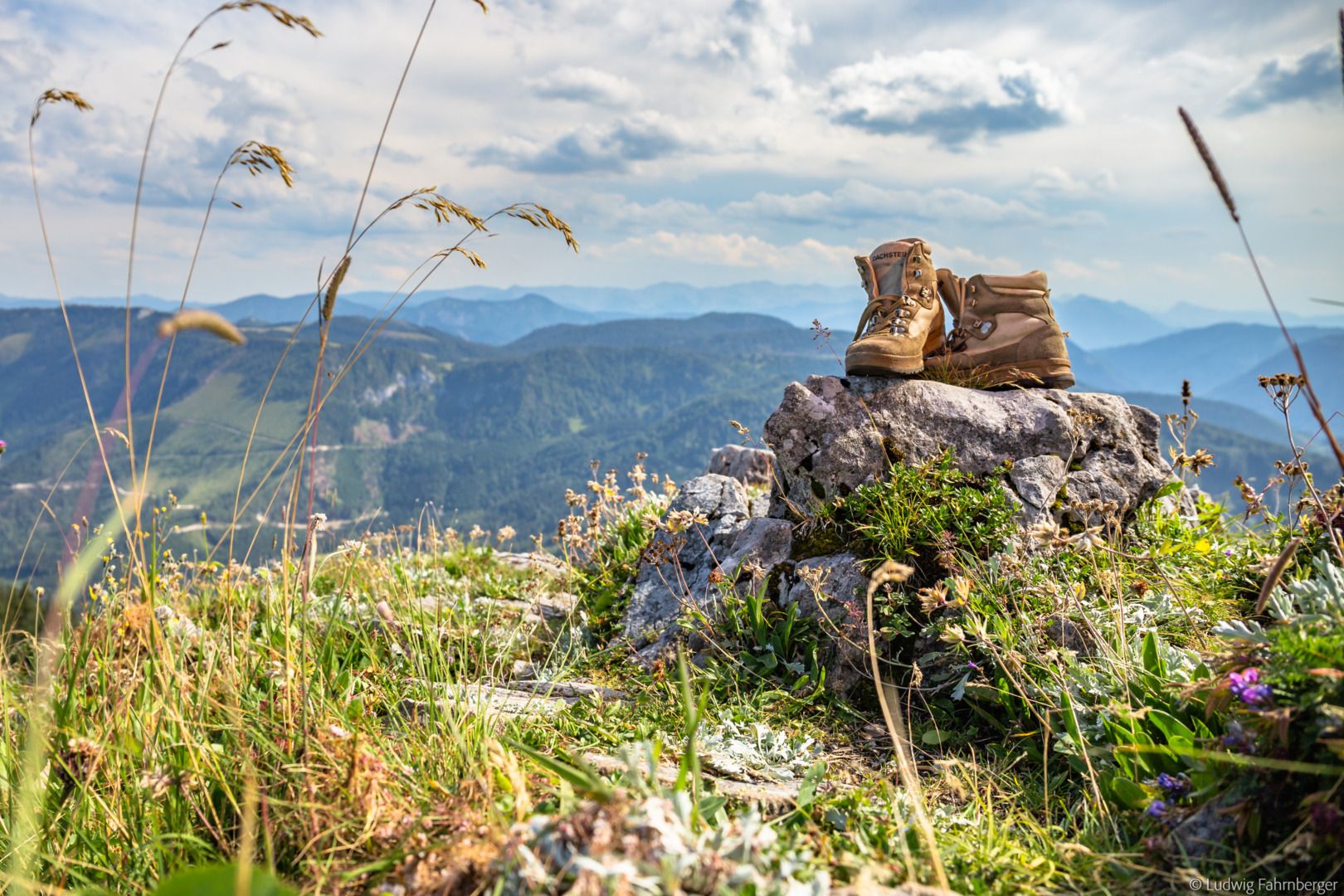 Wanderschuhe auf einem Felsen in einer Berglandschaft.