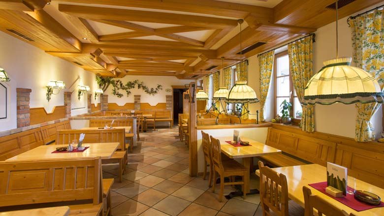 Innenansicht eines traditionellen Heurigenlokals mit Holzm&ouml;beln und gem&uuml;tlicher Beleuchtung.