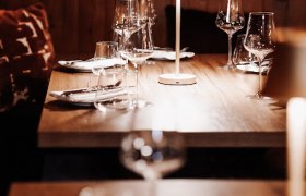 Eleganter Restauranttisch mit Weingläsern und Tischlampe.