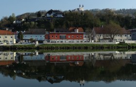 Stadtansicht von Marbach mit Gebäuden und Kirche, die sich im Wasser spiegeln.