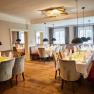 Elegantes Restaurant mit gedeckten Tischen, Polsterb&auml;nken und H&auml;ngelampen im Schloss Luberegg