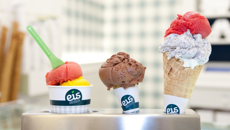 Drei Eissorten von Eis Greissler in Bechern und Waffel.