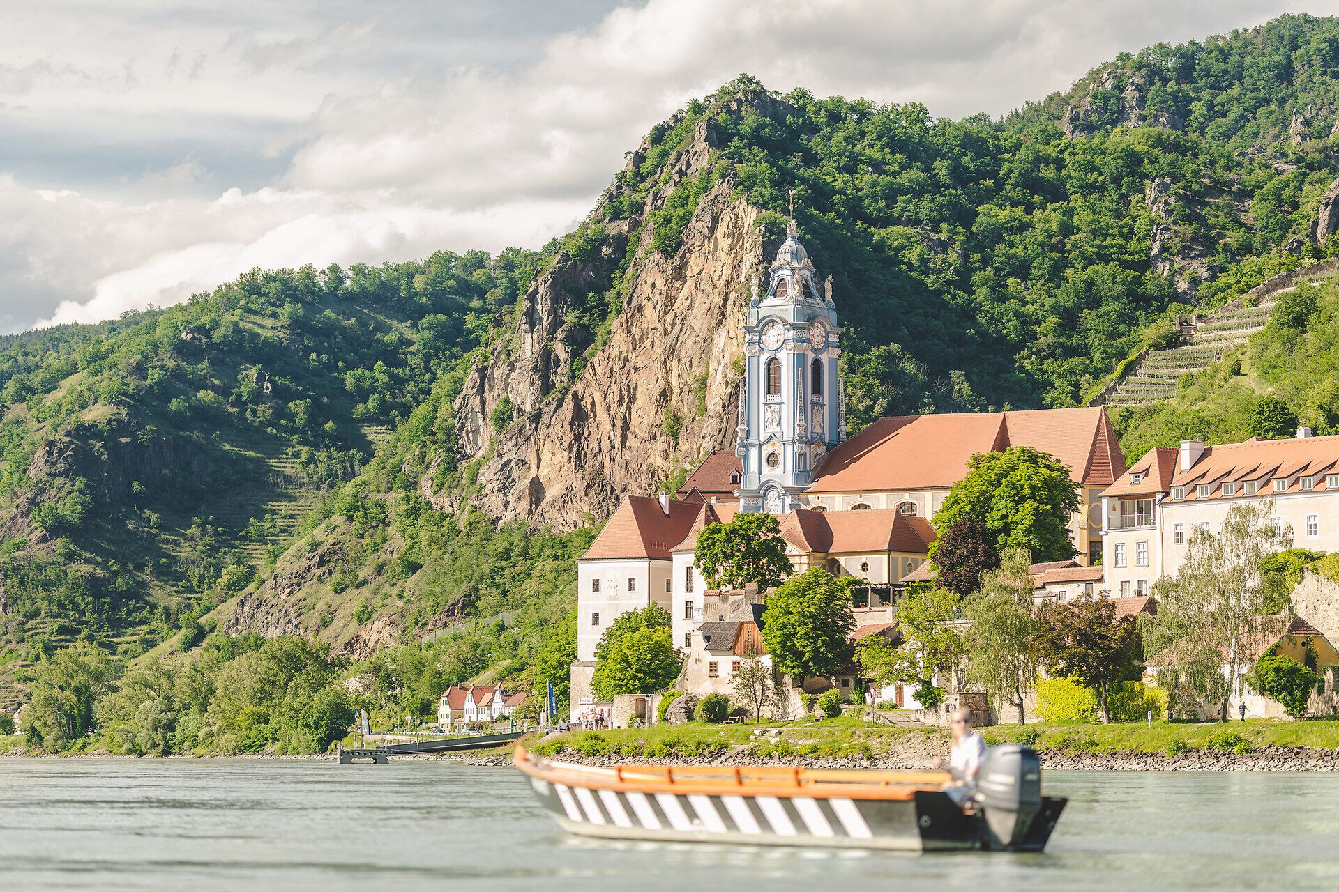 Eine Holzzille auf dem Wasser vor dem blauen Turm von Dürnstein.