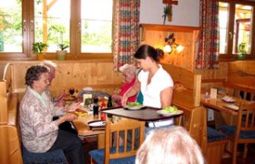 Innenansicht eines traditionellen &ouml;sterreichischen Heurigen mit G&auml;sten und Bedienung.