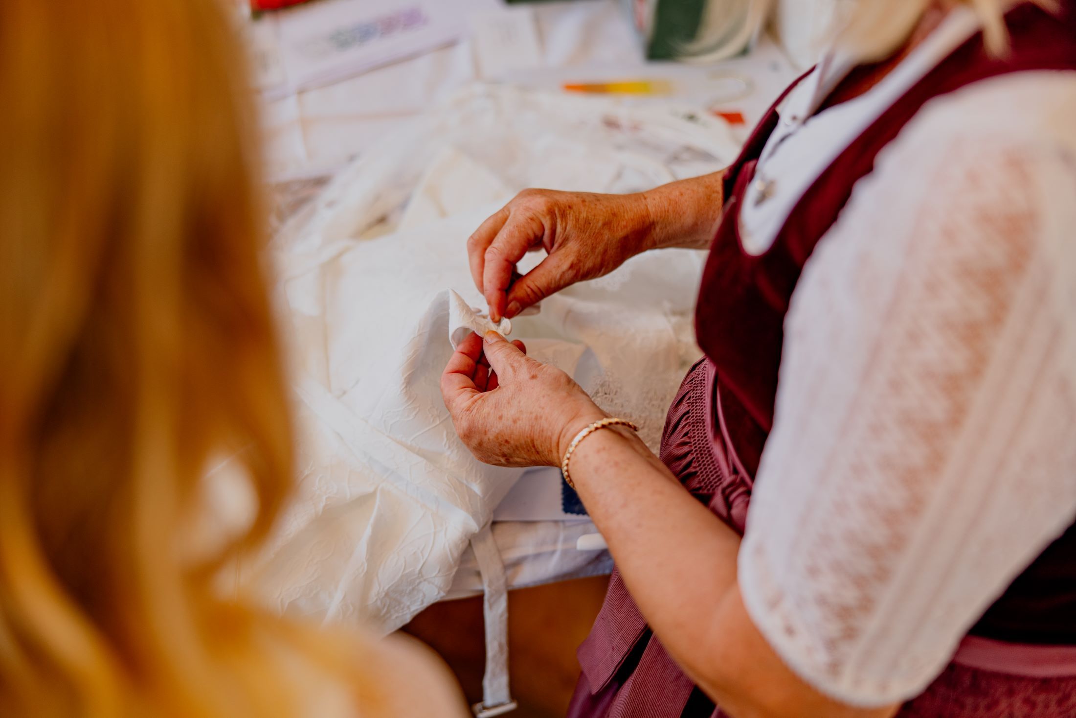 Nahaufnahme einer Person, die an einem weißen Stoff arbeitet.