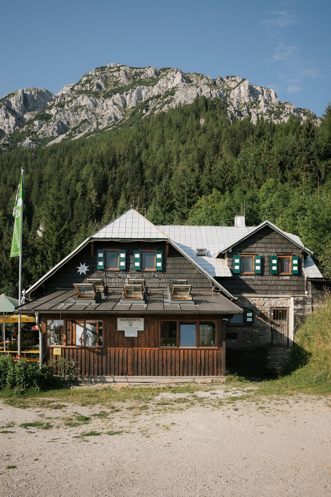 Außenansicht der Edelweißhütte am Schneeberg mit Felsmassiv im Hintergrund