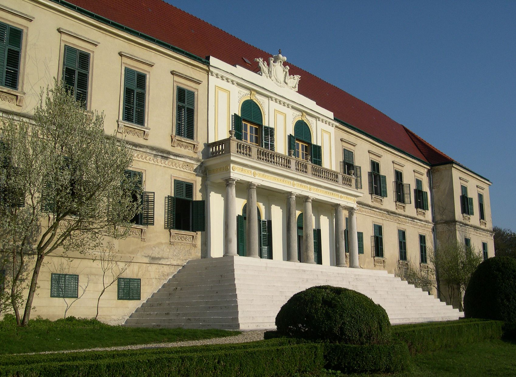 Schloss Loosdorf mit breiter Treppe und grünen Fensterläden.