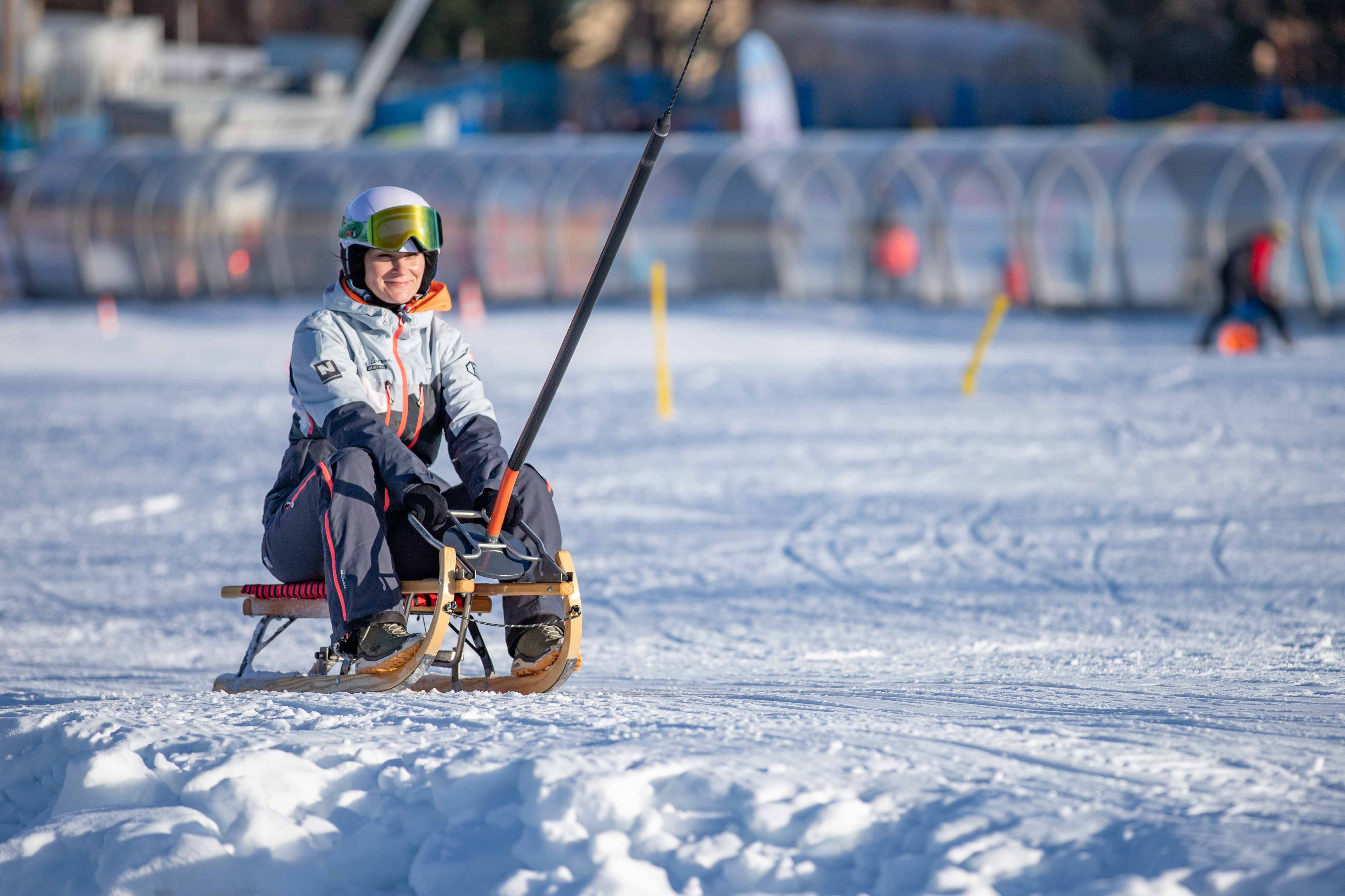 Innenansicht eines Sportgeschäfts mit Holzdecke und Kleidung auf Kleiderständern.