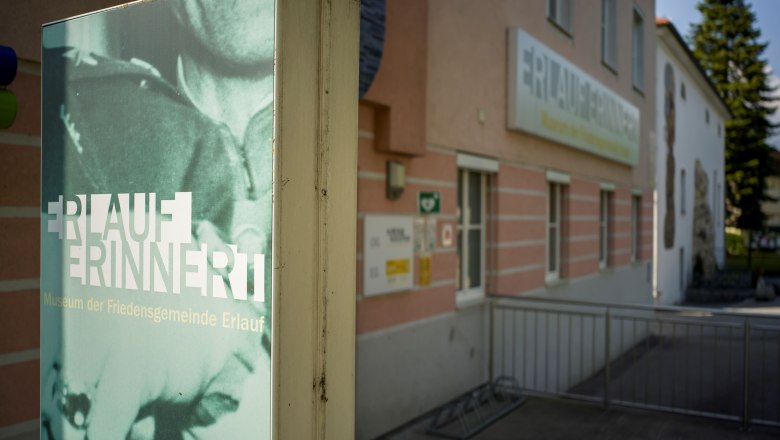 Au&szlig;enansicht des Friedensmuseums Erlauf mit Schild 'Erlauf erinnert'.