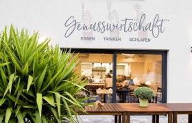 Außenansicht eines Restaurants mit der Aufschrift 'Genusswirtschaft'.