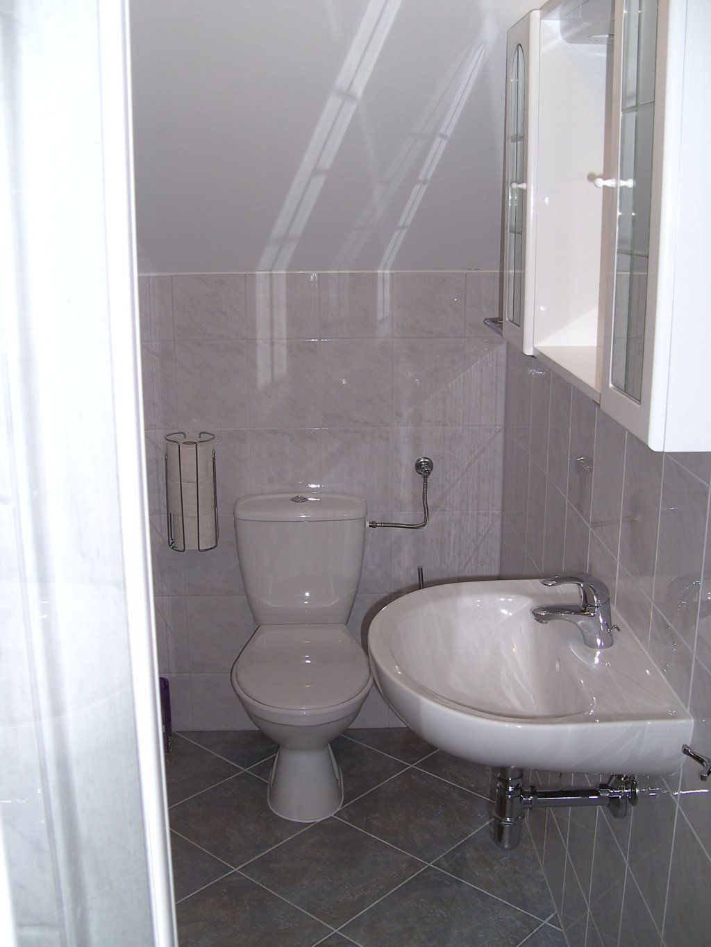 Kleines Badezimmer mit Toilette und Waschbecken.