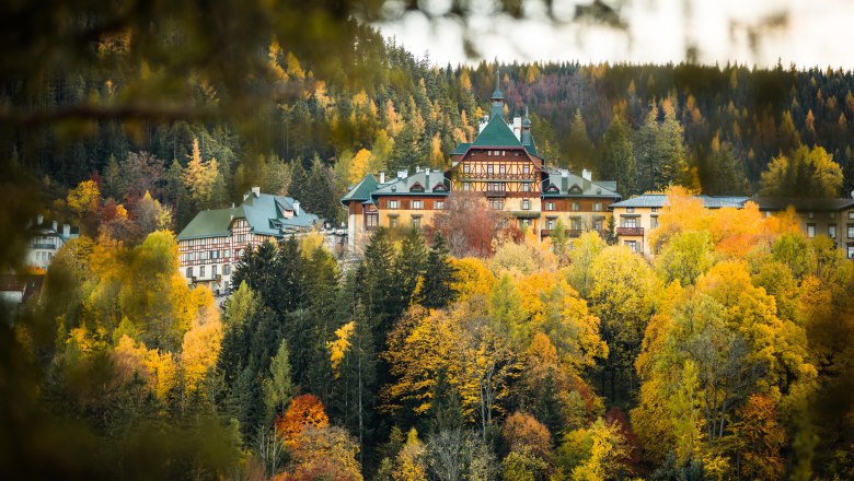 S&uuml;dbahnhotel Semmering im Herbst, umgeben von buntem Laubwald.