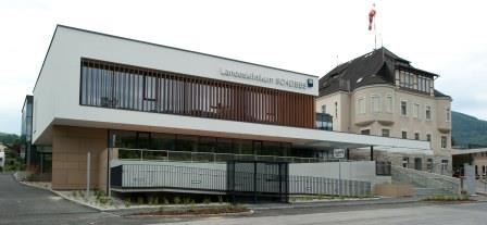 Modernes Geb&auml;ude des Landesklinikums mit Glasfassade und &auml;lterem Anbau.