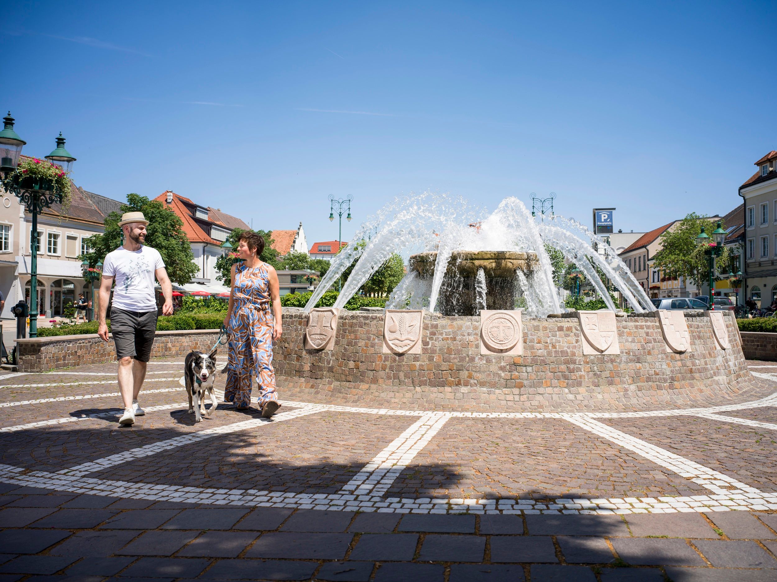 Spaziergänger am Bezirksbrunnen am Hauptplatz Tulln
