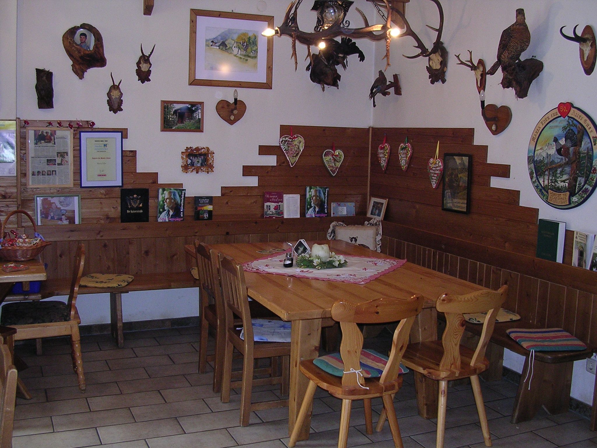 Gemütliche Stube mit Holzmöbeln und Jagdtrophäen an den Wänden.