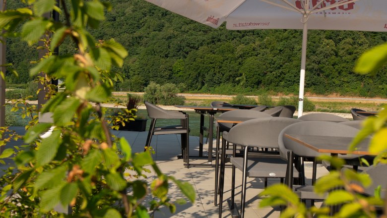 Tische auf der Terrasse mit grünen Pflanzen