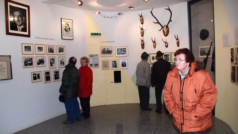 Besucher im Leopold Figl Museum betrachten Fotos und Jagdtrophäen an den Wänden.