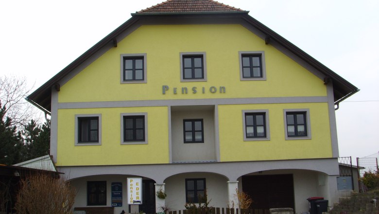 Gelbes Geb&auml;ude mit der Aufschrift 'Pension'.