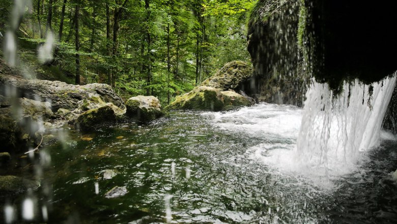 Wasser stürzt über Felsen nach unten und spritzt.