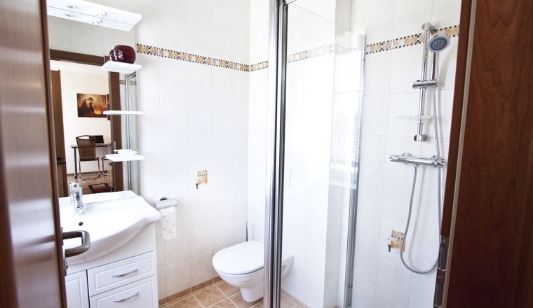 Badezimmer, © Pension Theresa Modernes Badezimmer mit Dusche, Waschbecken und Toilette.
