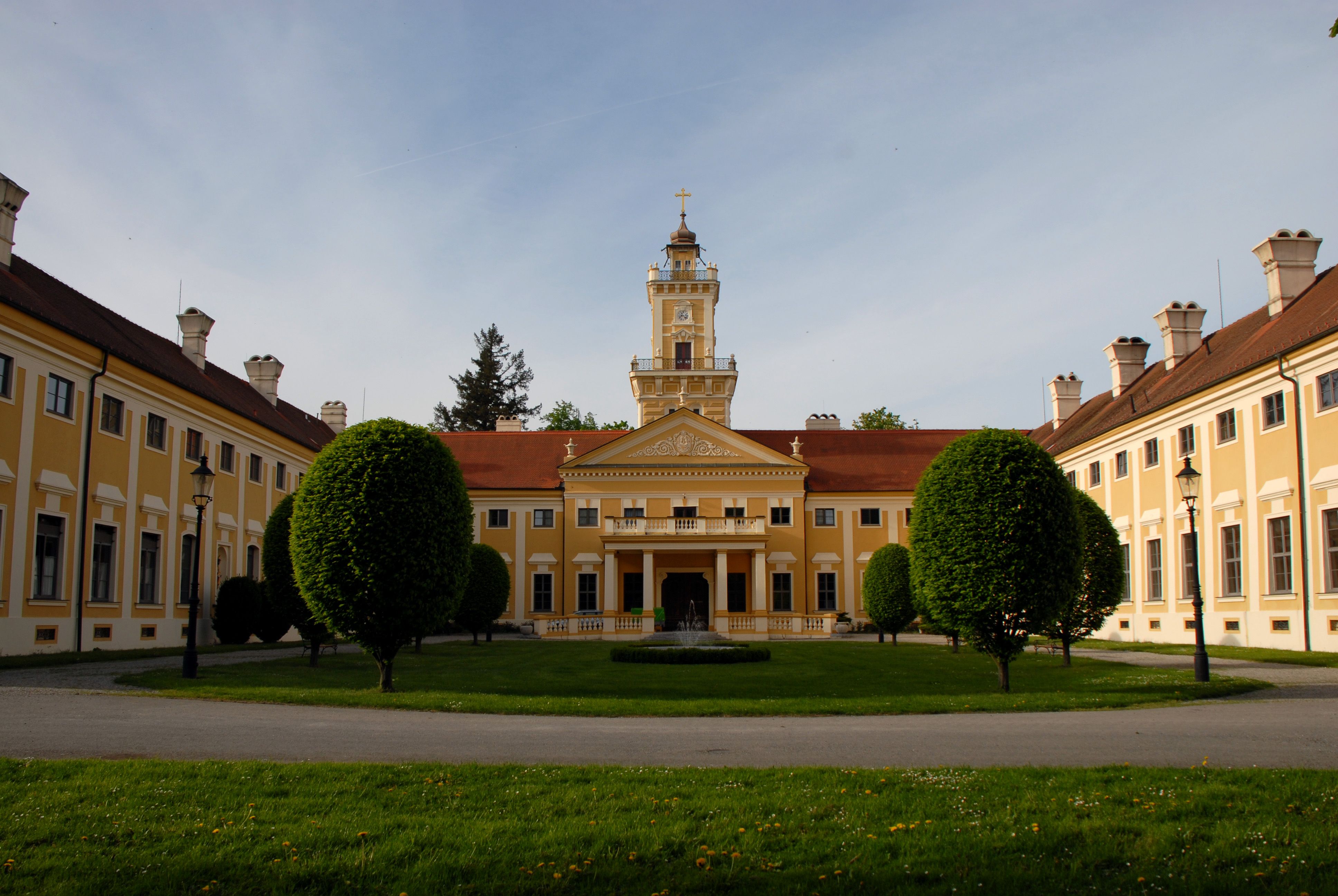 Schloss Jaidhof mit gelber Fassade und Turm, umgeben von gepflegtem Garten.