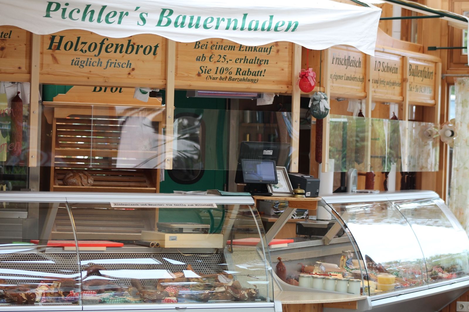 Innenansicht eines Bauernladens mit Theke und Holzofenbrot.