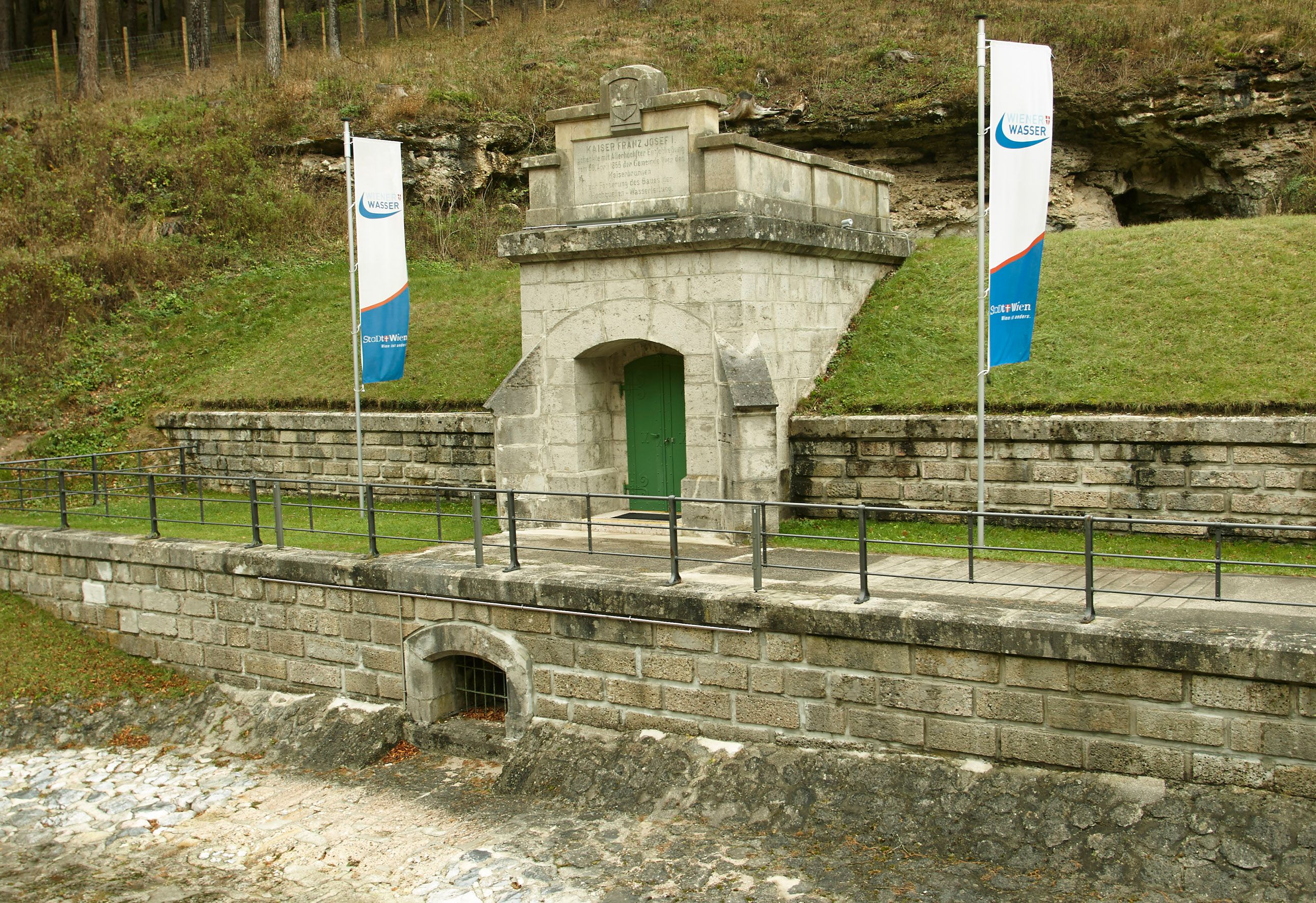 Eingang des Wasserleitungsmuseums Kaiserbrunn mit zwei Fahnen.