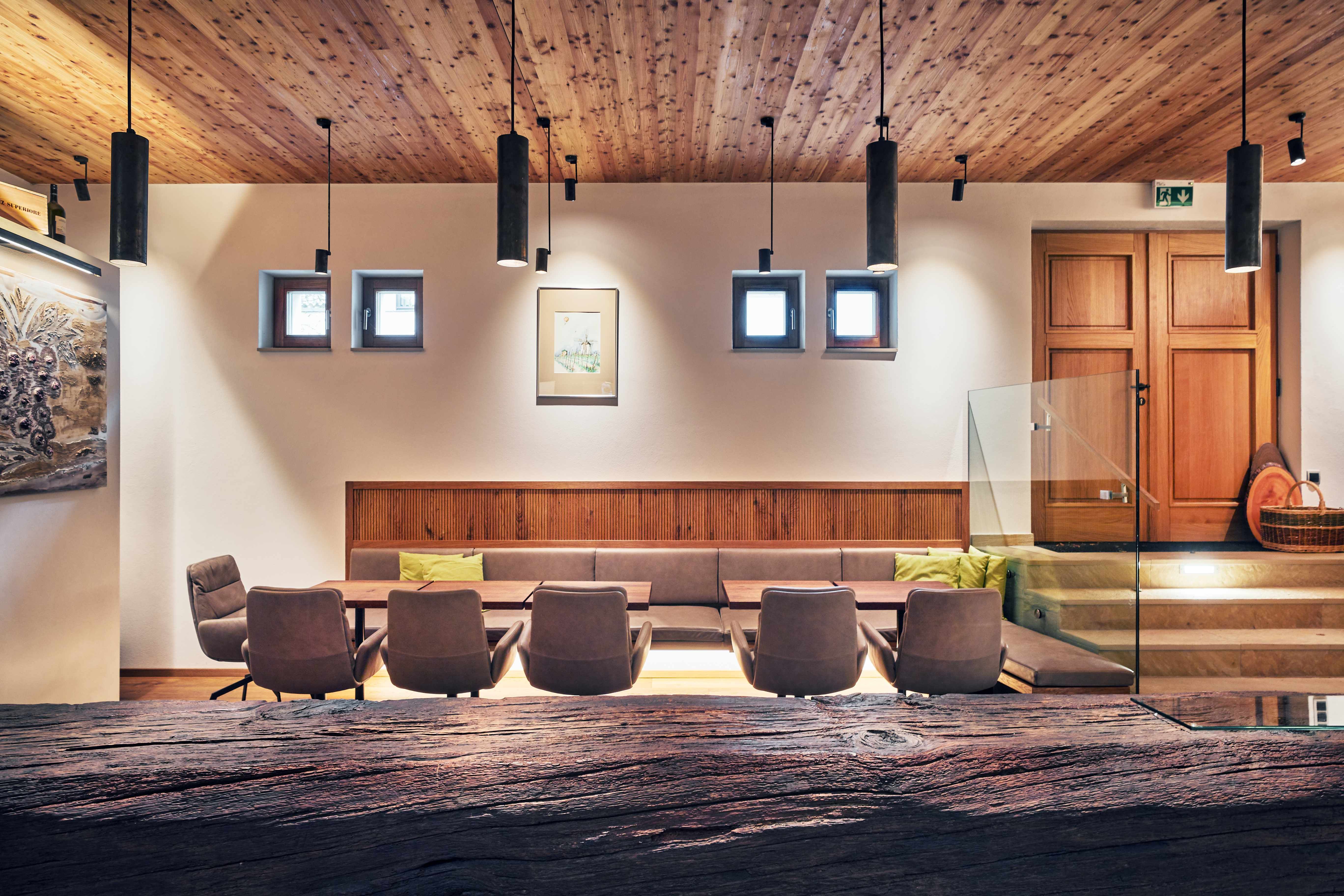 Moderner Innenraum mit Holzelementen, Sitzbereich und dekorativen Lampen.