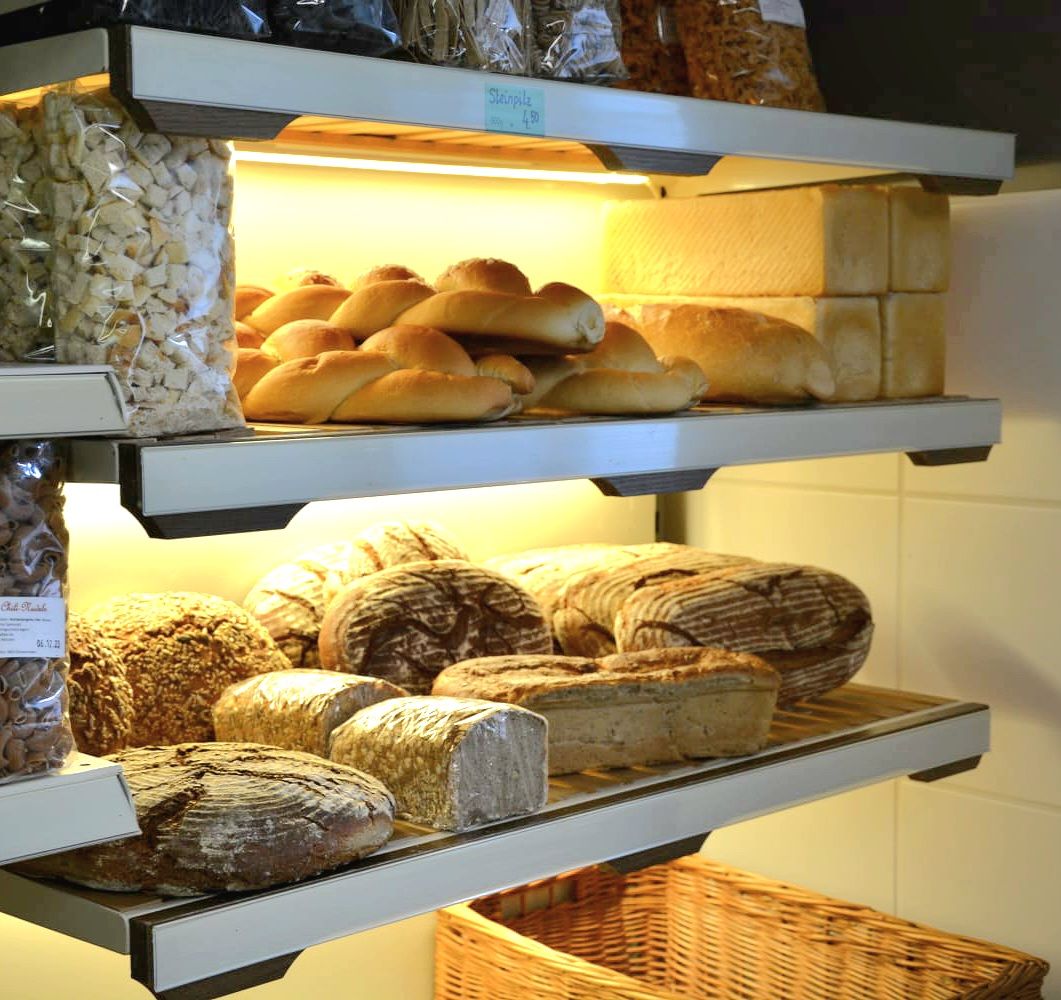 Regale mit verschiedenen Brotsorten und Gebäck in einer Bäckerei.