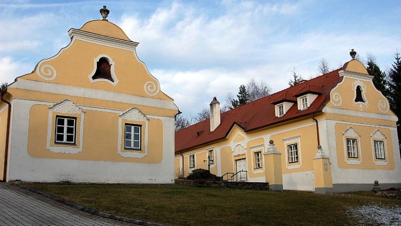 Historischer Pfarrhof Krumbach mit gelben Fassaden und roten D&auml;chern.