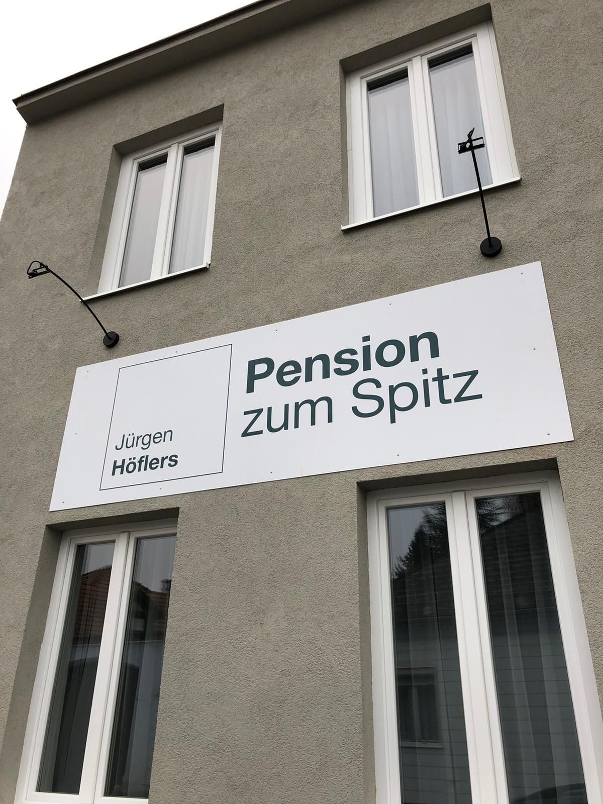 Fassade eines Gebäudes mit einem Schild der Pension zum Spitz.